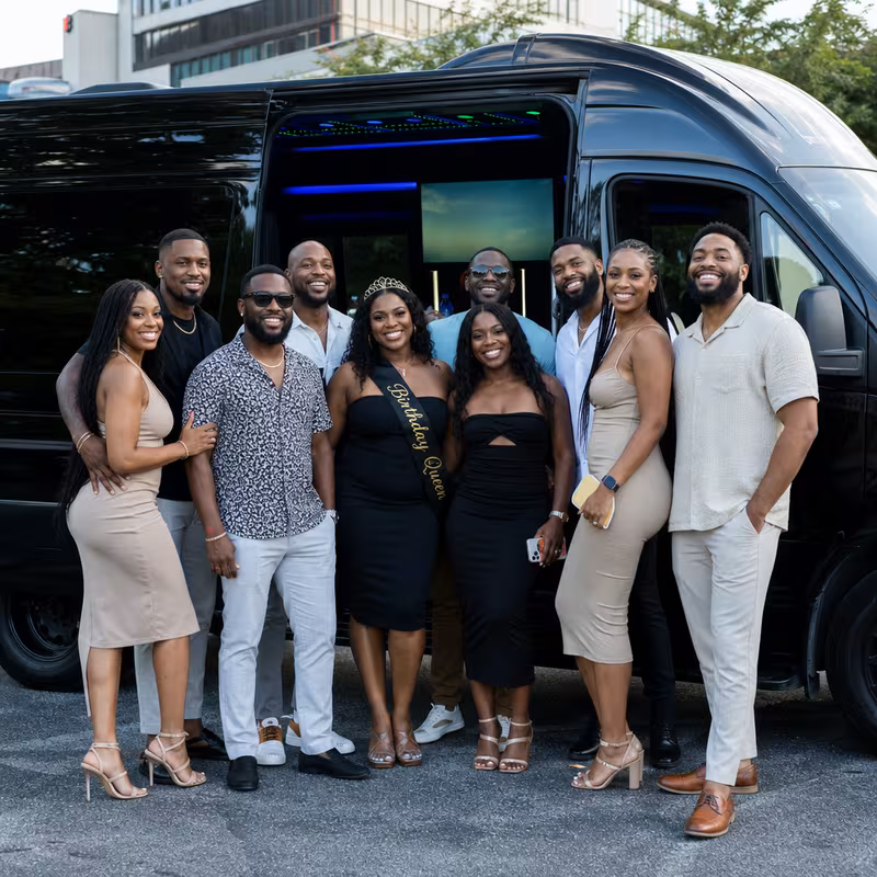 Group boarding a white charter bus for Birthday Transportation transportation in New Orleans