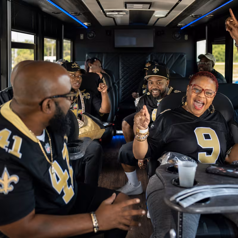 Group boarding a white charter bus for Sporting Event Transportation transportation in New Orleans